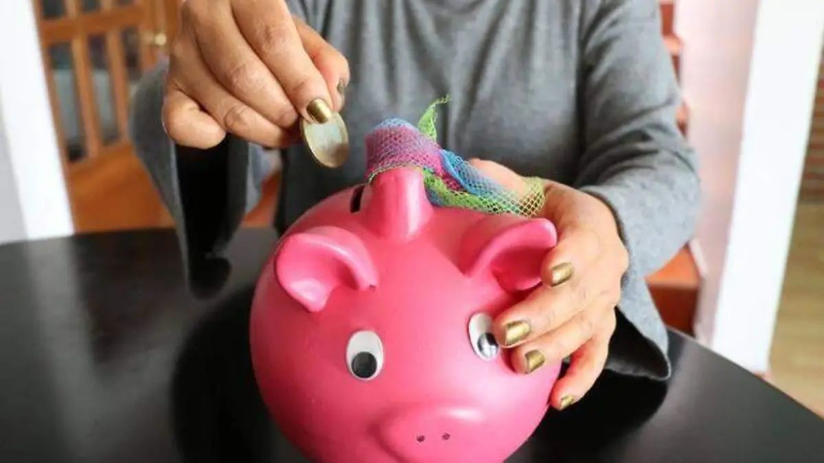 Mujer metiendo monedas en una alcancía